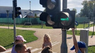 Dzieci stoją przy sygnalizatorze świetlnym