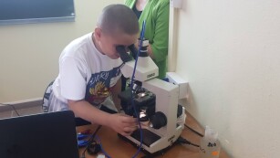 Uczeń ogląda preparat w mikroskopie
