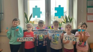 Dzieci prezentują hasło związane z autyzmem